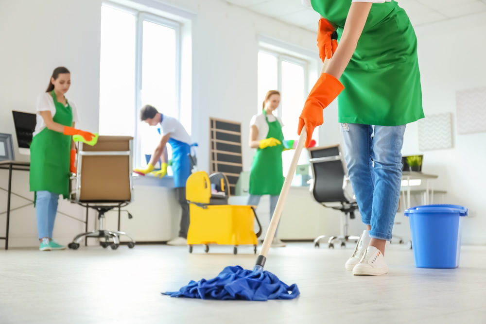 Janitorial Service Bonds protect your customers from theft and show credibility 4-person cleaning crew in an office
