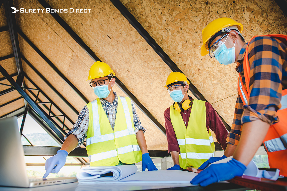 Contractors examining plans while wearing masks
