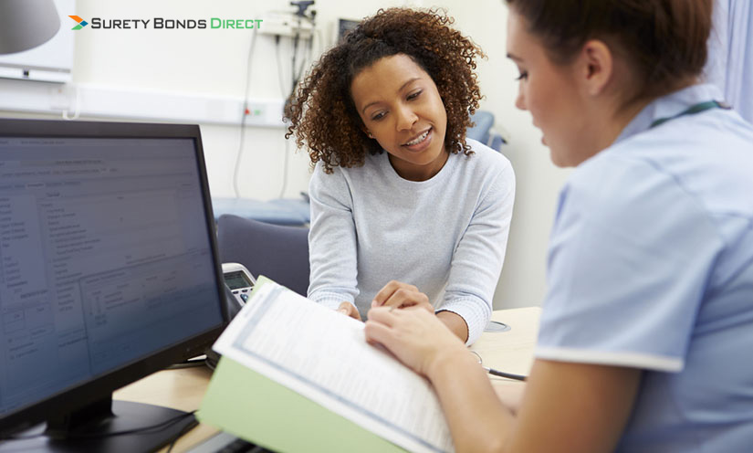 Woman reviewing documents with a medical professional